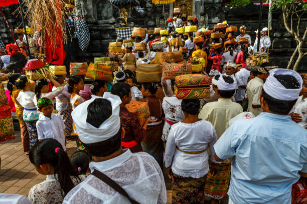 i balinesi con le loro offerte entrano nel tempio della grotta dei pipistrelli (pura goa lawah) a klungkung, bali, indonesia, asia - pura goa lawah foto e immagini stock