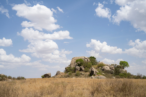 An inselberg in the african savanna in Tanzania, on a partially cloudy day.