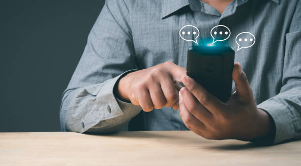 istock Man hand using smartphone typing Live chat chatting and social network concepts, chatting conversation working at home in chat box icons pop up. Social media marketing technology concept. 1460295288
