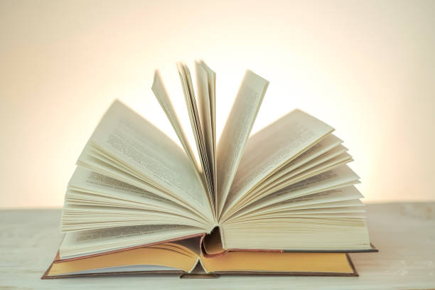 istock stack of books on a wooden table on a light white blurred background. soft focus.Learning and knowledge symbol. 1460295920