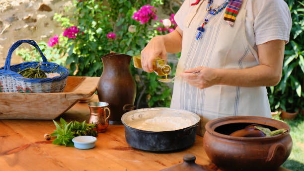 Mediterranean Woman Pouring Olive Oil On Dough