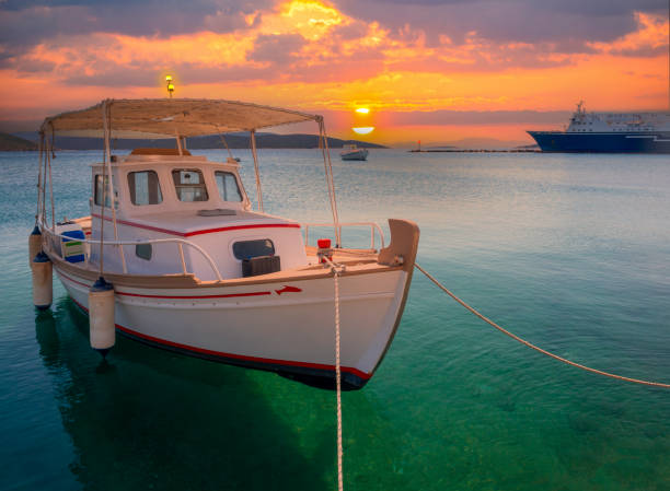 kuvapankkikuvat ja rojaltivapaat kuvat aiheesta valkoinen kalastusvene markiisilla kreikkalaisen lomakaupungin marmarin satamassa auringonlaskun aikaan evian saarella kreikassa - euboea