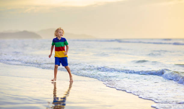 istock Child playing on ocean beach. Kid at sunset sea. 1460306460