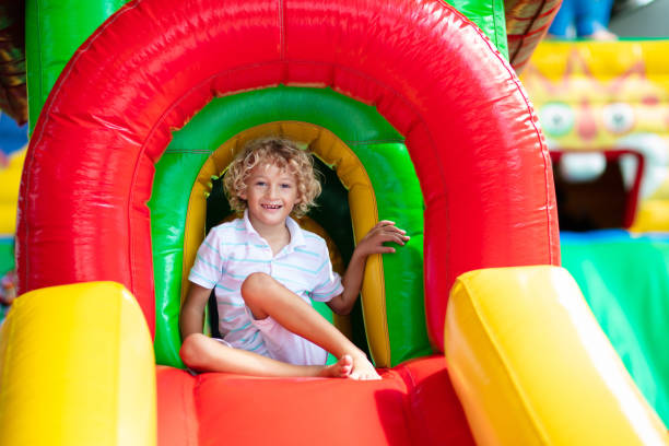 istock Child jumping on playground trampoline. Kids jump. 1460310187
