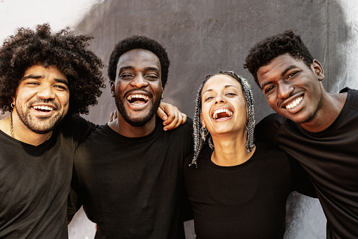 Happy group of multiracial people having fun laughing in front of camera outdoor