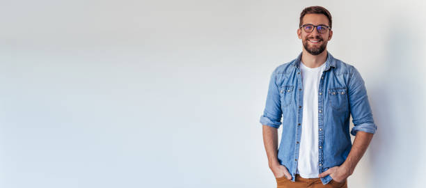 Isolated shot of young handsome man with beard, wearing casual clothes, posing in studio on white background stock photo