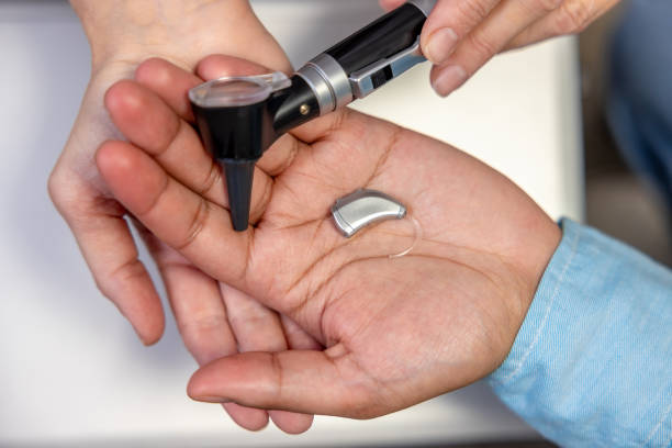 istock Close up of a hearing aid on males hand 1460314511