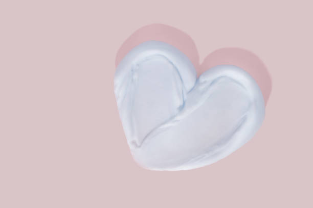 istock Heart shape from cream on pink background. 1460317280