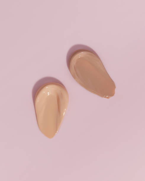 istock Makeup foundation, beige concealer swatch smudge smear on pink background. BB CC cream texture 1460317289