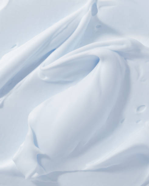 Blue mousse foam creamy texture. Cosmetic cleanser, soap, cream, shampoo sample. Foamy skincare product smear smudge stock photo