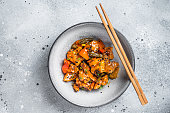 Chinese Sweet and Sour Pork guo bao rou in a bowl. Gray background. Top view