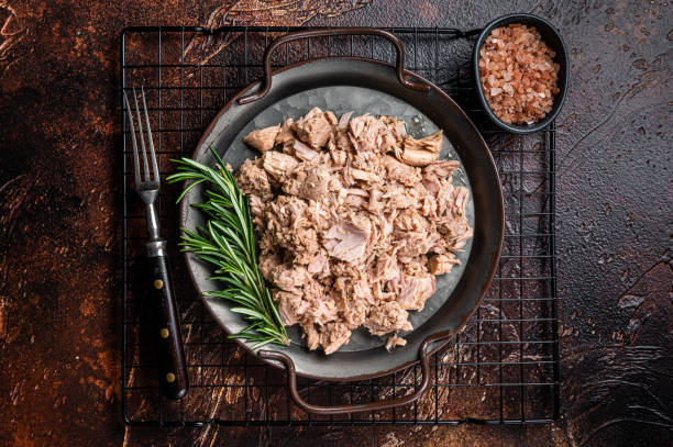 istock Canned tuna with fresh herbs ready for eat. Dark background. Top view 1460327360