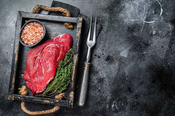 istock Fresh Raw veal meat with herbs and salt. Black background. Top view. Copy space 1460327464