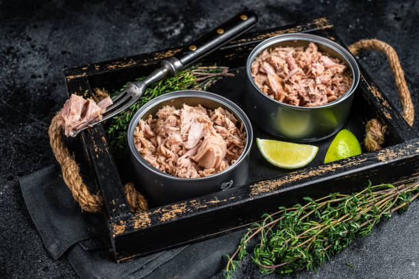 istock Open Can with Preserved tuna fillet meat. Black background. Top view 1460328266