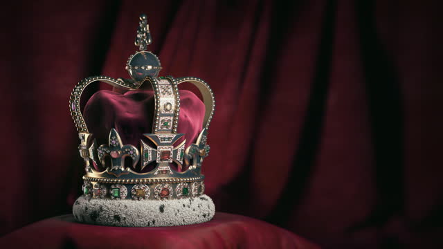 Royal golden crown with jewels on pillow on pink red background. Symbols of UK United Kingdom monarchy. 3d loopable seamless video animation