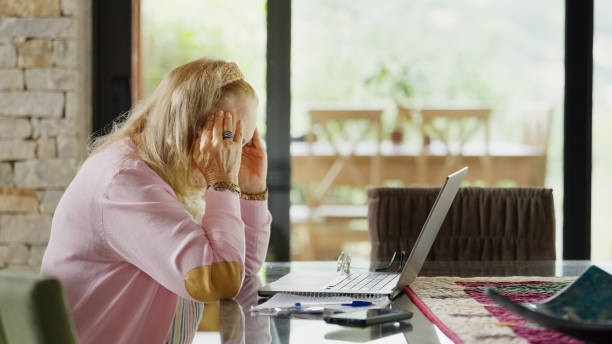 istock Senior woman looking worried working on home budget using laptop 1460333539