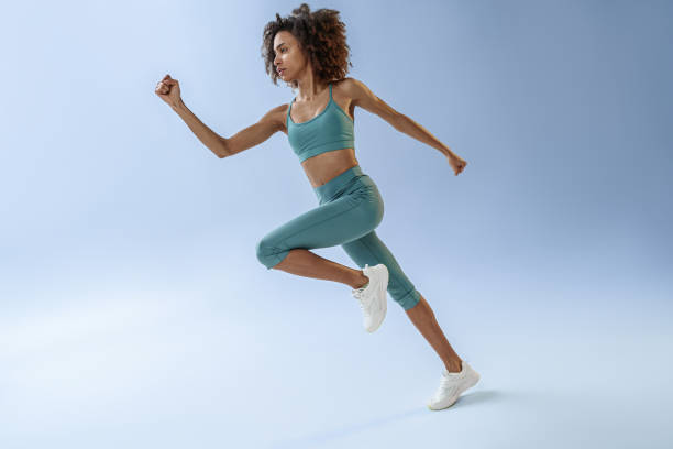 istock Sporty determined woman running during cardio workout over studio background 1460335071