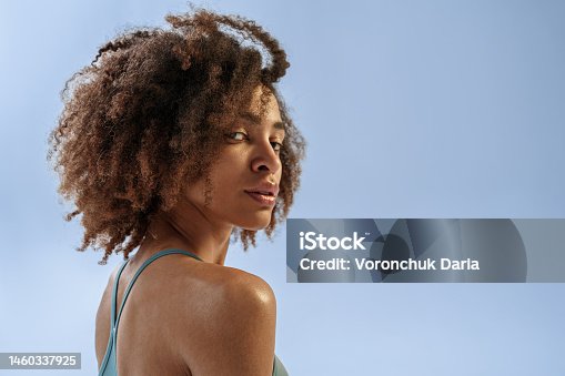 istock Portrait of beautiful sporty woman in sportswear looking at camera on studio background 1460337925