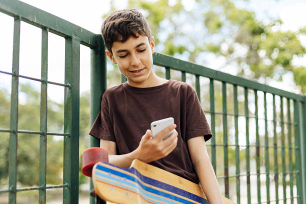 istock 13 years old boy using smartphone outdoors. 1460341649
