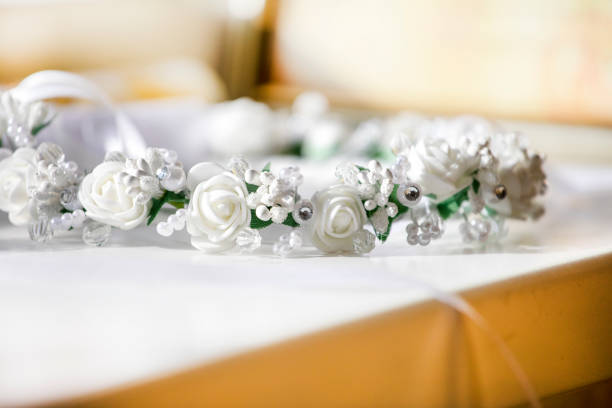 white festive wreath with artificial flowers on a light background