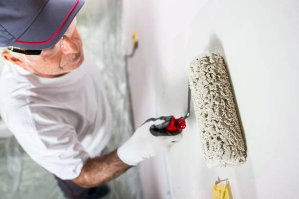 istock Painter Applying Light Color Paint To The Wall 1460348365