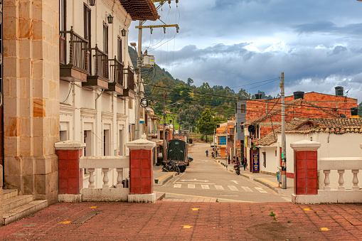 Sesquilé, Colombia -  One of the main carreras leading into the main plaza in the Andean town of Sesquilé, in the Cundinamarca Department of the South American country of Colombia. The town is located at an elevation of about 8500 feet above mean sea level. In the background is the always-present Andes Mountains. Photo shot in the morning sunlight in the horizontal format. Copy Space.