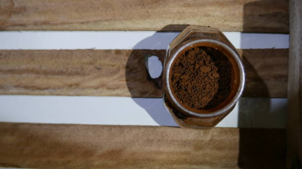 mesa de madeira: uma cafeteira em pó. café moído sobre a mesa. - coffee book instant coffee cappuccino - fotografias e filmes do acervo