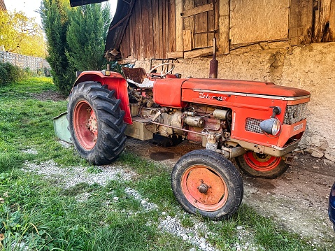 Menthon saint Bernard, France - October 23 2021: a rusted vintage tractor is parked next to a farm on the french countryside and is a zetor 4511 model