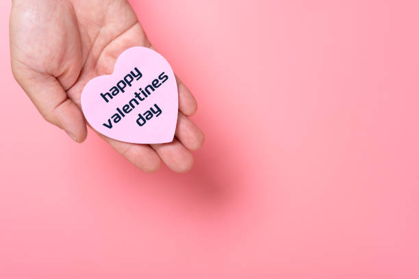 istock man holding a heart shape paper written with happy valentines day with copy space 1460363499