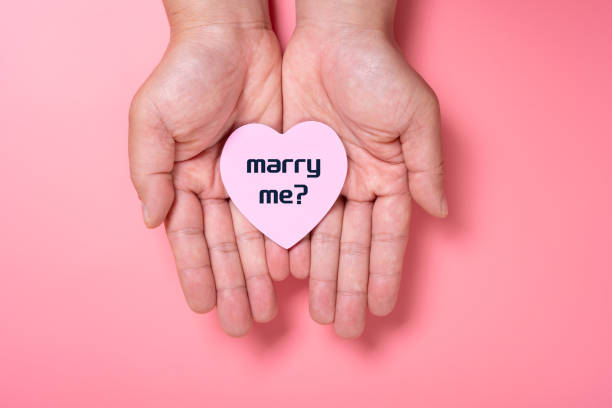 istock man holding a heart shape paper written with marry me 1460363750