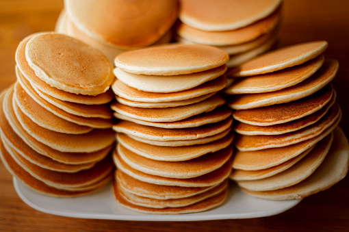 Closeup view of a plate full of freshly, homemade, stacked pancakes