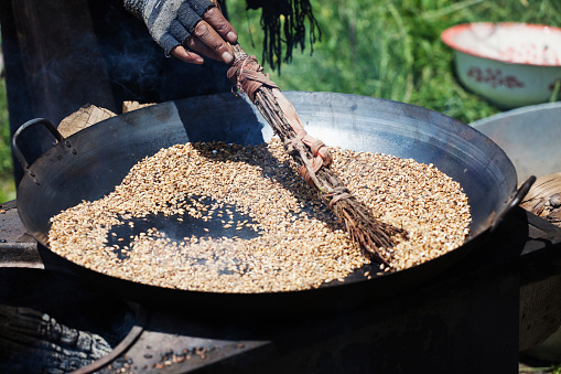 Traditional tools to grind cereals such as millet and sorghum in Burkina Faso. These tools are a fiber broom, a calabash which contains the grains, a small stone and a large flat one (grindstones).