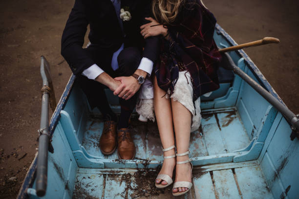 Bride and groom with a flannel blanket in a rowboat
