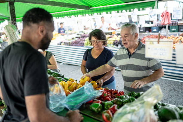 clientes que eligen frutas y verduras en un mercado callejero - 50 days old fotografías e imágenes de stock