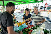 Customers choosing fruits and vegetables on a street market