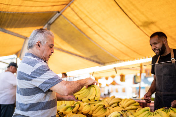 istock Customer choosing bananas on a street market 1460371323