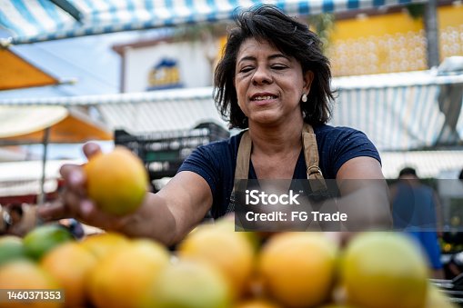 istock Saleswoman organizing the fruits on a street market 1460371353