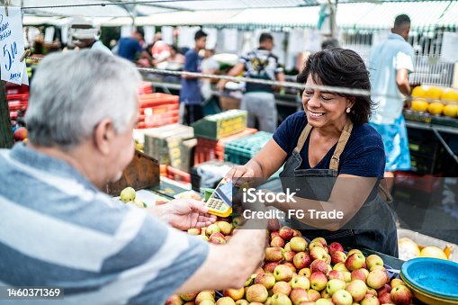 istock Customer paying with credit card on a street market 1460371369