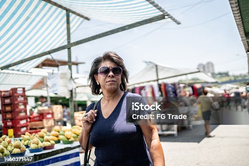 istock Mature woman customer walking on a street market 1460371447