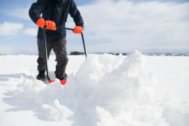 man shoveling snow after snowstorm