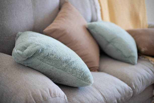 Living room interior with green and brown pillows on sofa.