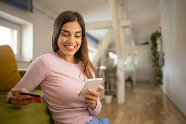 istock Cheerful  young woman doing online shopping 1460385627