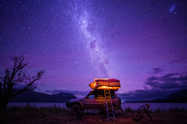 a camper van at nightfall near water body. - travel locations fotos imagens e fotografias de stock