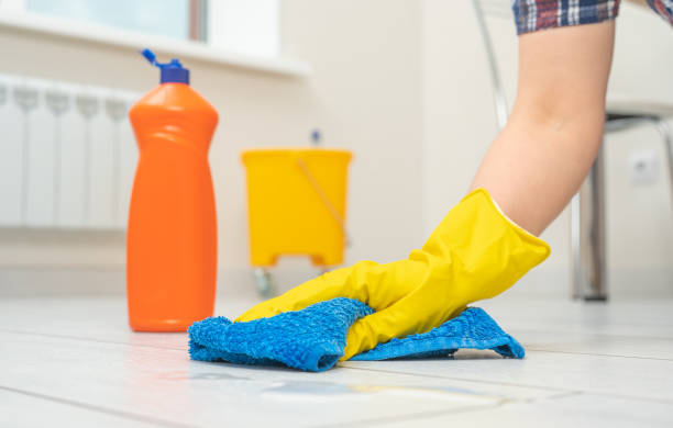 mujer con guantes limpiando piso. producto de limpieza y cuidado para laminados y pavimentos. manos femeninas con guantes amarillos limpie el piso de madera con un paño azul de microfibra - scrubbing up fotografías e imágenes de stock