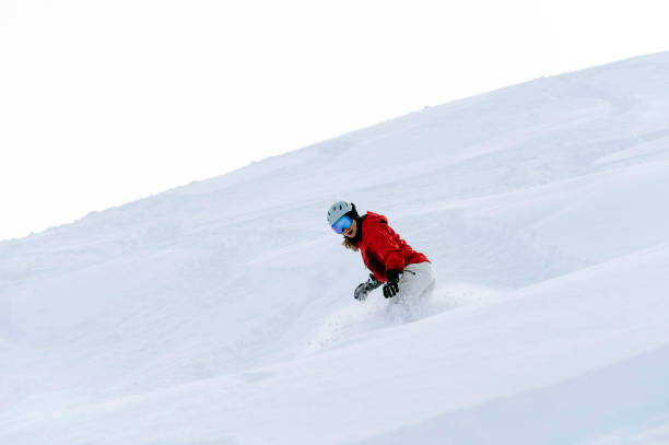 istock Woman snowboarding in fresh powder 1460394420