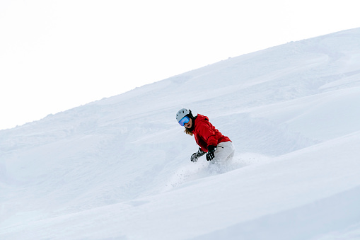 Deep powder snow at Whistler, BC, Canada. Woman on a winter snowboard vacation.