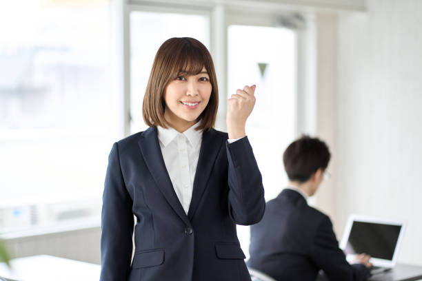 istock Asian business woman doing a guts pose in a seminar room 1460394590