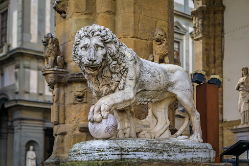 Statue of one of Medici lions in the Loggia dei Lanzi in front of Palazzo Vecchio on public Square of Signoria in Florence, Italy