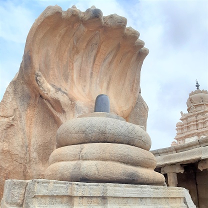 the rock sculpture of the lord shiva in lingam form with gaint five headed serpent