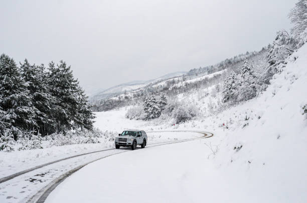4x4 pickup truck going uphill on forest road in winter